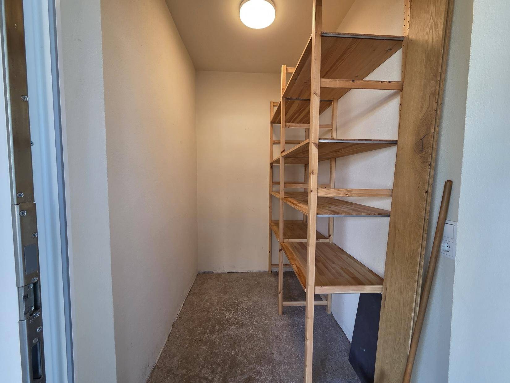 Praktischer Abstellraum mit stabilen Holzregalen für zusätzlichen Stauraum.