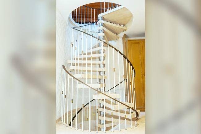 Eleganter Flur mit einer modernen Wendeltreppe und hellen Wänden.