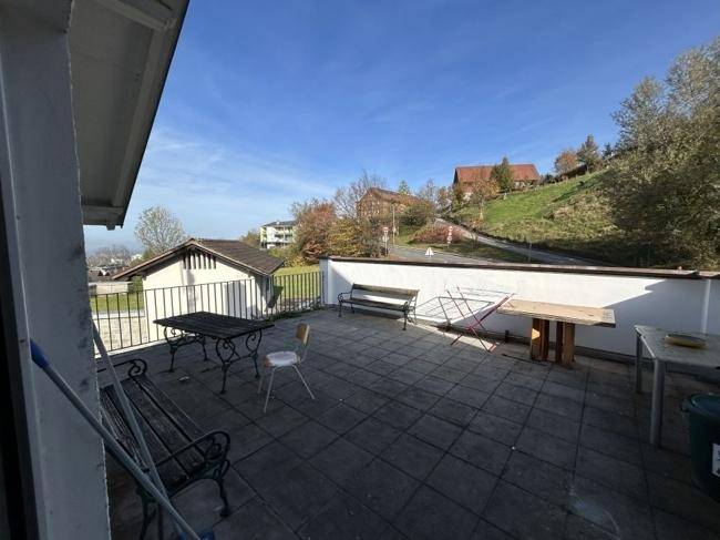Große Dachterrasse mit Fliesenboden, Gartenmöbeln und weitem Blick über die Landschaft.