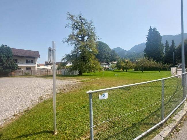 Weitläufiges Grundstück mit Zaun und Blick auf die umliegende Berglandschaft.
