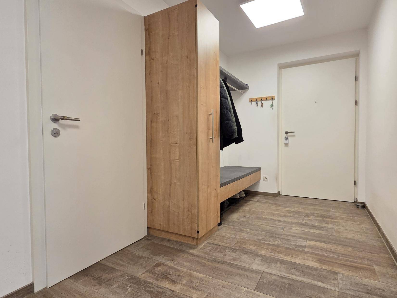 Eingangsbereich mit praktischer Garderobe, Sitzbank und Schuhschrank für Ordnung.