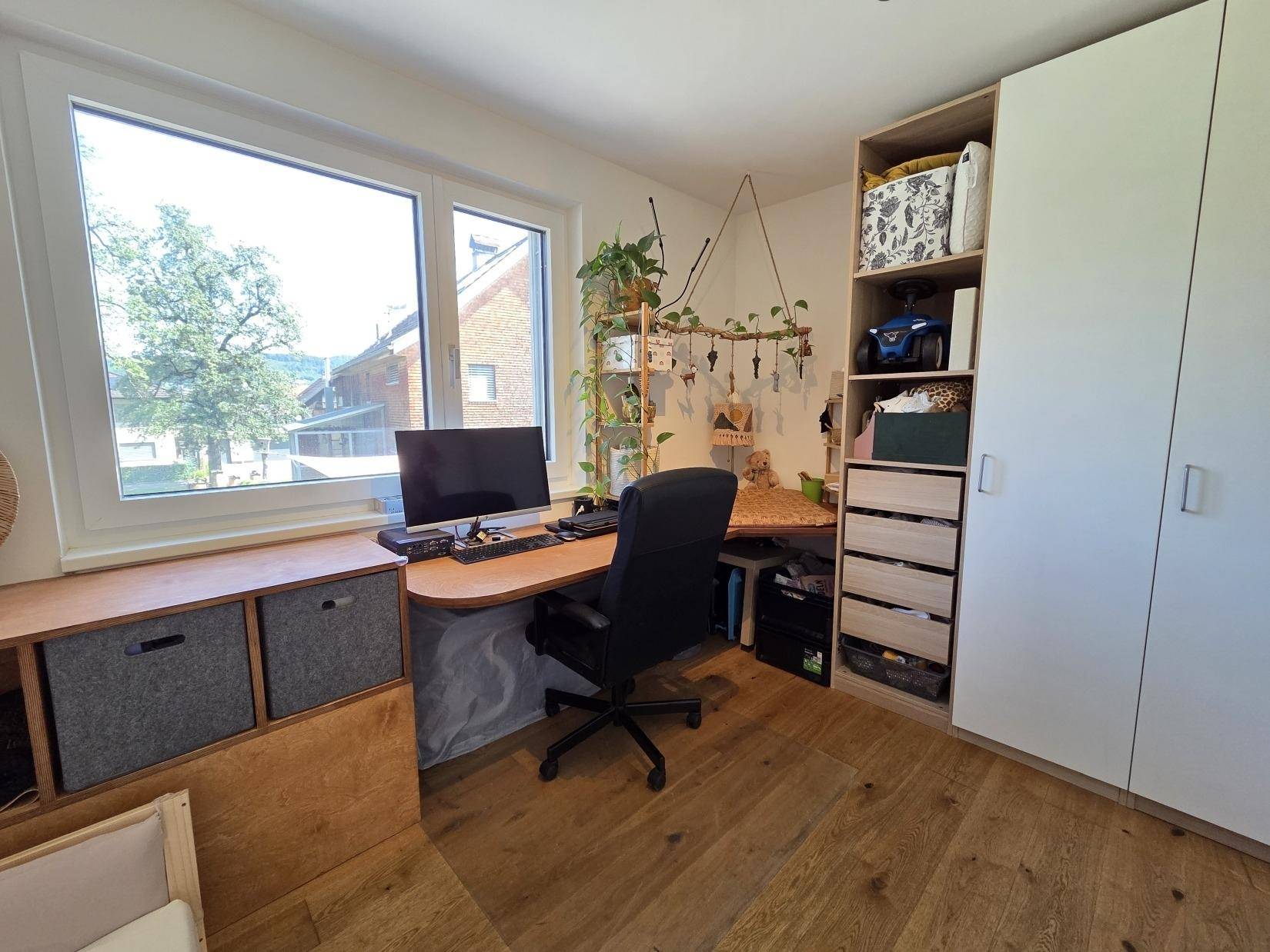 Helles Arbeitszimmer mit Schreibtisch, Bürostuhl und praktischen Regalen, ideal für Home-Office.