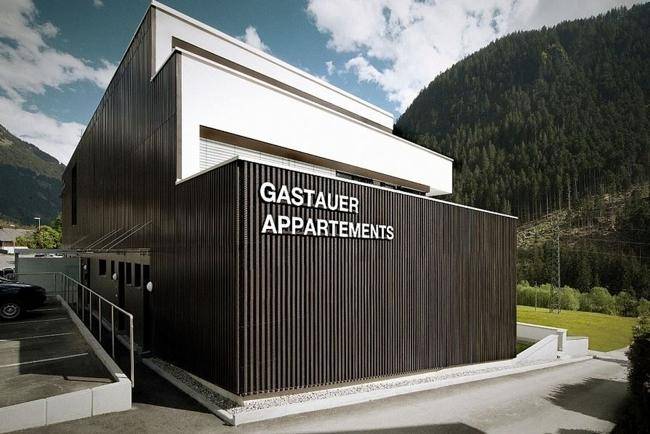 Modernes Apartmentgebäude mit Holzfassade und Beschriftung "Gastauer Appartements".