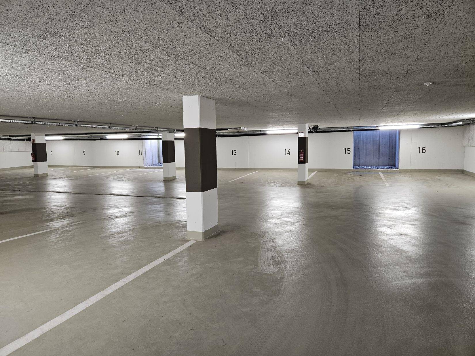 Geräumige Tiefgarage mit markierten Stellplätzen und Säulen.