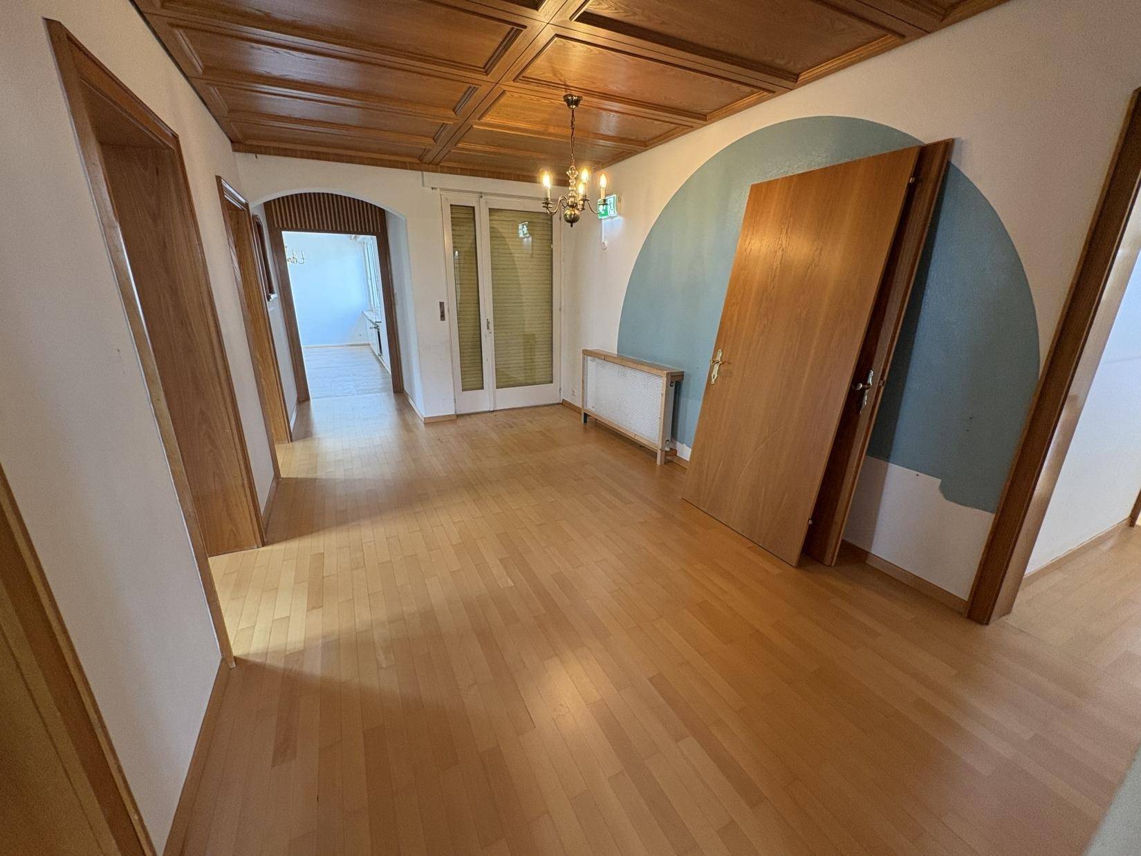 Geräumiger Flur mit Parkettboden, Holzkassettendecke und Zugang zu weiteren Räumen.
