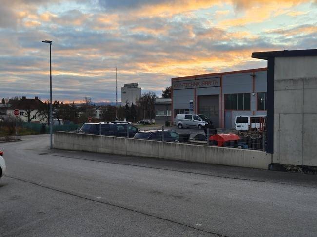 Blick auf ein benachbartes Gebäude mit Werkstatt und die umliegende Straße bei Sonnenuntergang.