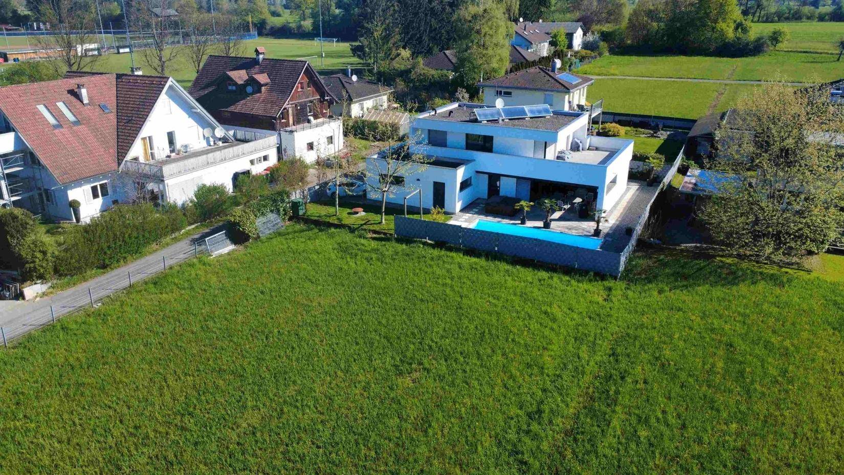 Weitläufige Luftaufnahme einer modernen Villa mit Pool und großem Grundstück in ländlicher Umgebung.