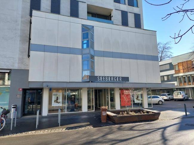 Moderne Geschäftsfassade mit großen Schaufenstern und dem Schriftzug "SEEBERGER" in der Stadt.