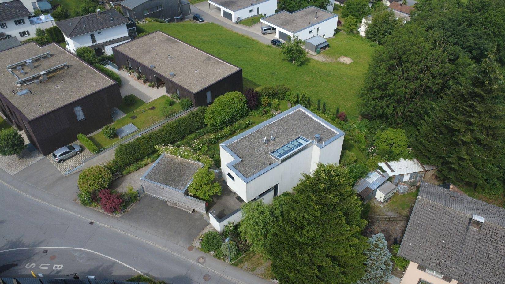 Luftaufnahme des modernen Hauses mit Garten und der umliegenden Wohngegend.