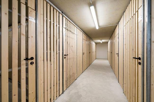 Lange Reihe von Kellerabteilen mit Holzlattenwänden für zusätzlichen Stauraum.