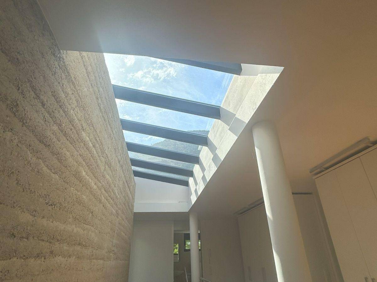 Heller Treppenaufgang mit großem Oberlicht, das viel natürliches Licht in den Raum bringt.