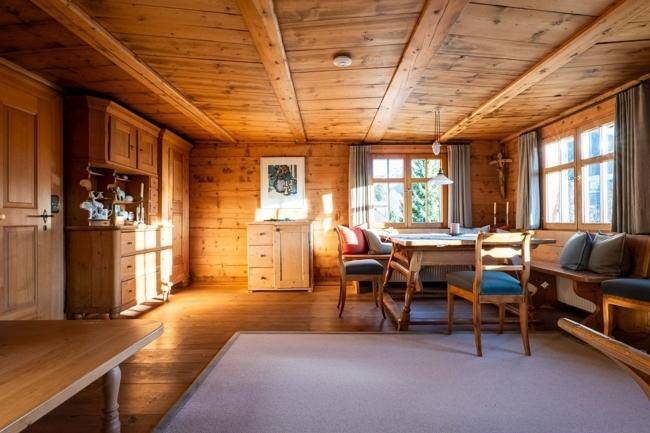 Gemütlicher Essbereich mit Holztäfelung, Holzbalkendecke und einem großen Esstisch.