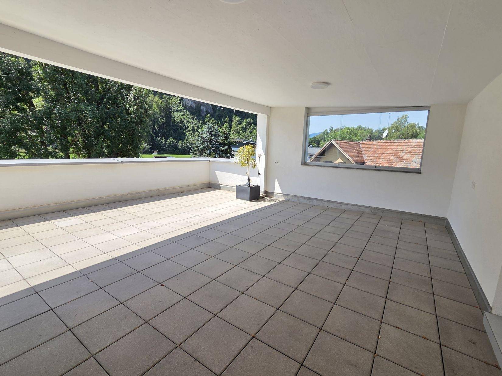 Helle und weitläufige Terrasse mit Fliesenboden, ideal für Entspannung im Freien.