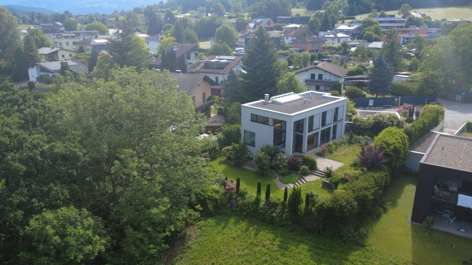 Übersicht aus der Luft des Anwesens mit dem modernen Haus und der weitläufigen Grünfläche.