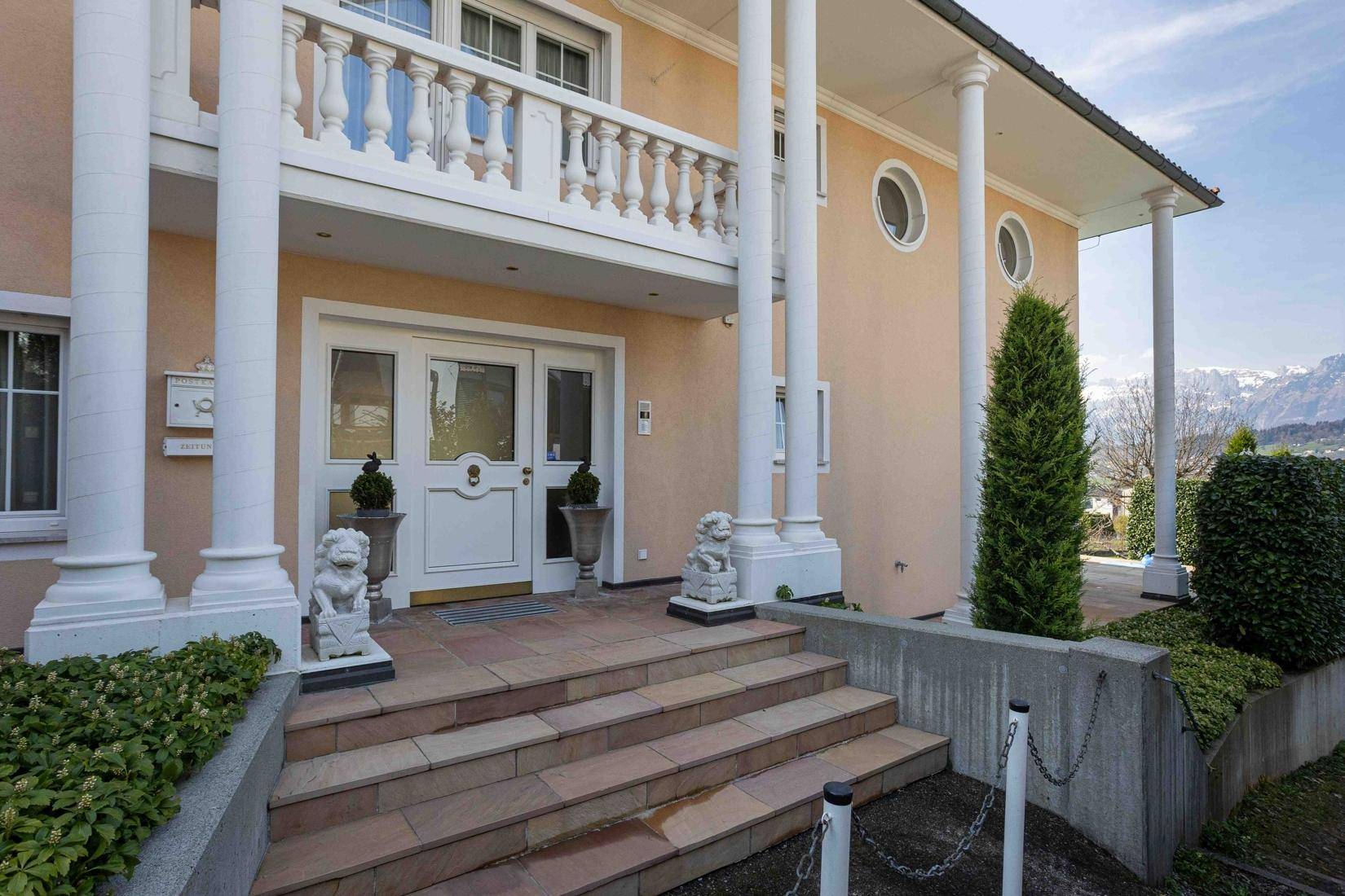 Repräsentativer Haupteingang der Villa mit Säulen und breiter Steintreppe.