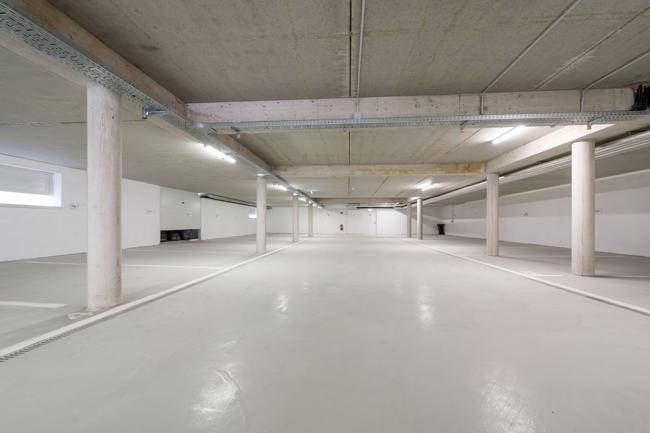 Helle Tiefgarage mit Betonstützen und ausreichend Platz für Fahrzeuge.