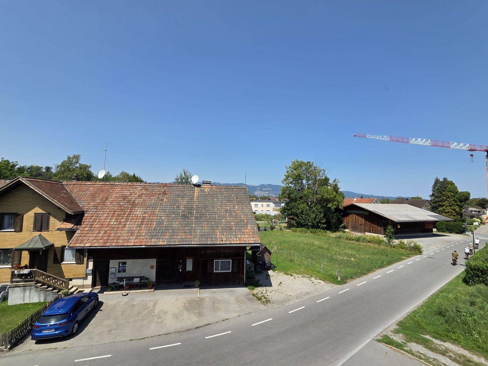 Blick auf die ländliche Umgebung mit traditionellen Häusern und einer ruhigen Straße.