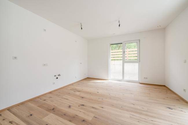 Heller Raum mit Holzboden und großem Fenster, ideal für individuelle Gestaltung.