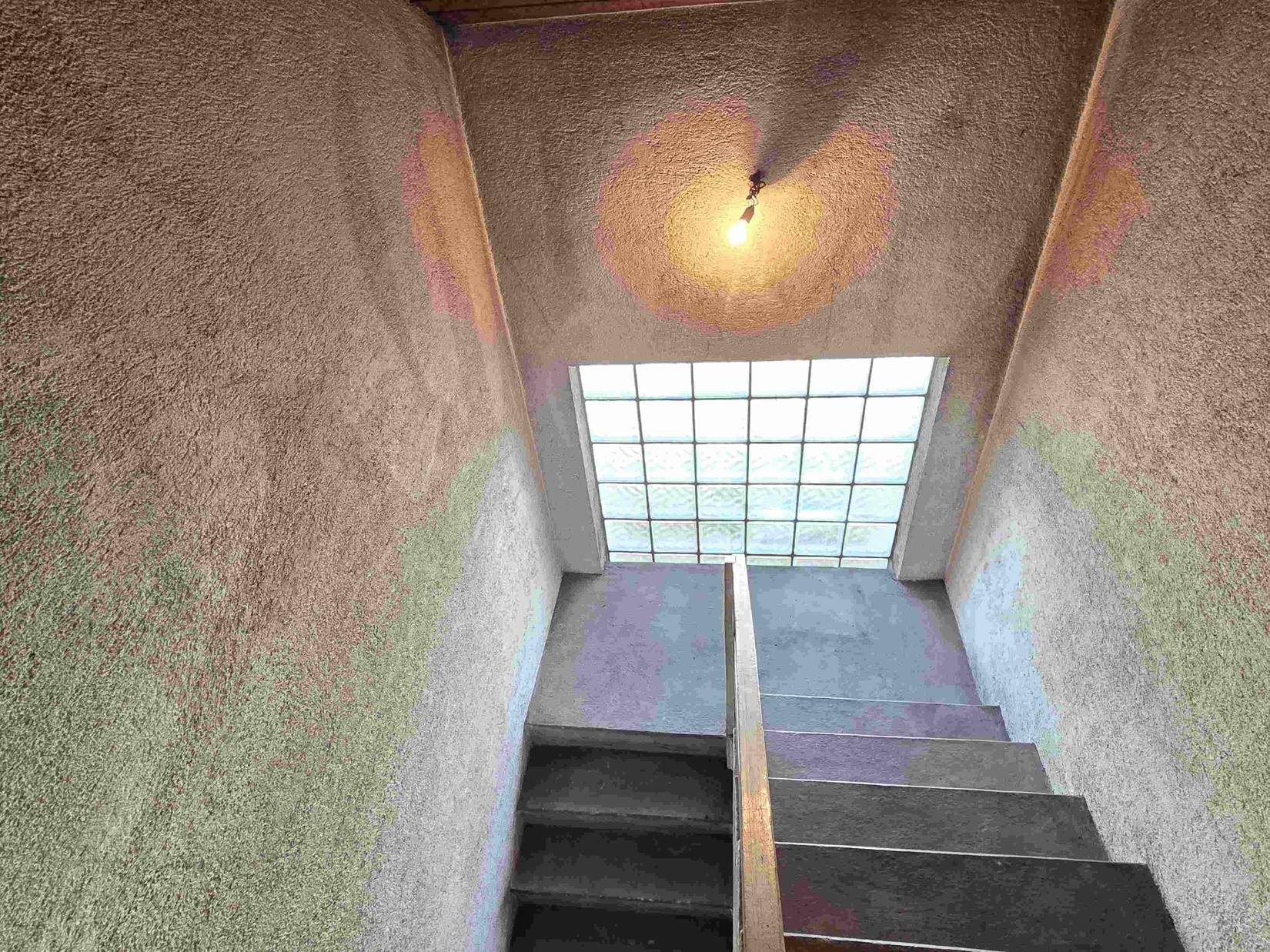 Treppenhaus mit Glasbausteinfenster, das natürliches Licht in den Bereich bringt.