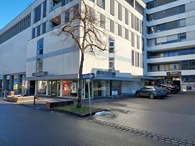 Gebäudeansicht von der Straße mit dem Schriftzug "SEEBERGER" und parkenden Autos.