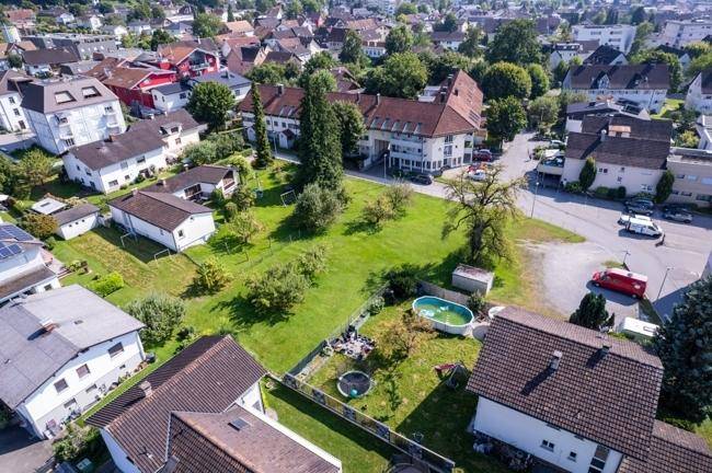 Weitläufige Luftaufnahme des Anwesens mit großem Garten und angrenzenden Häusern.