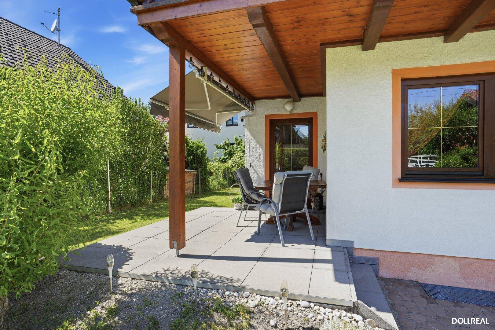 Überdachte Terrasse mit Gartenmöbeln und Blick ins Grüne, ideal für entspannte Stunden im Freien.