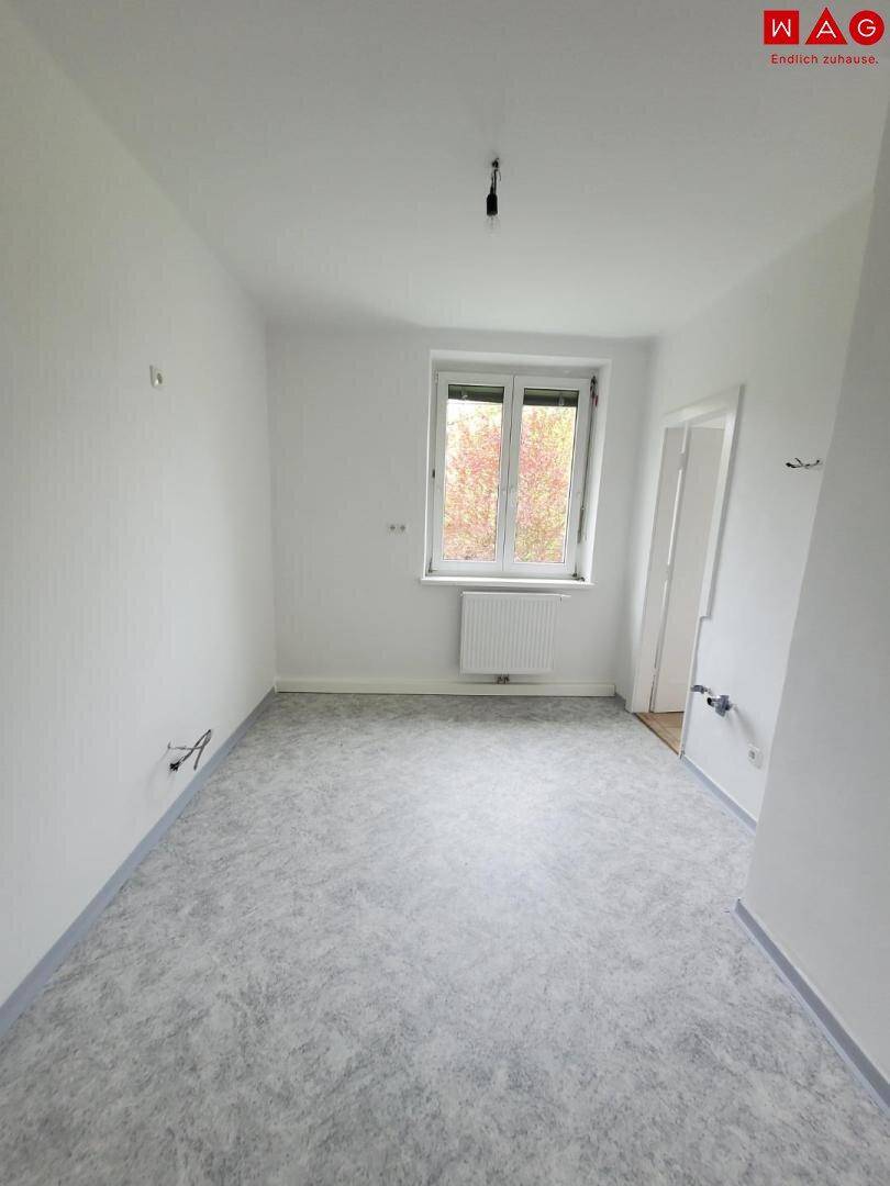 Kleiner Raum mit neuem Bodenbelag und Fenster, möglicherweise für ein Büro oder als Abstellraum.