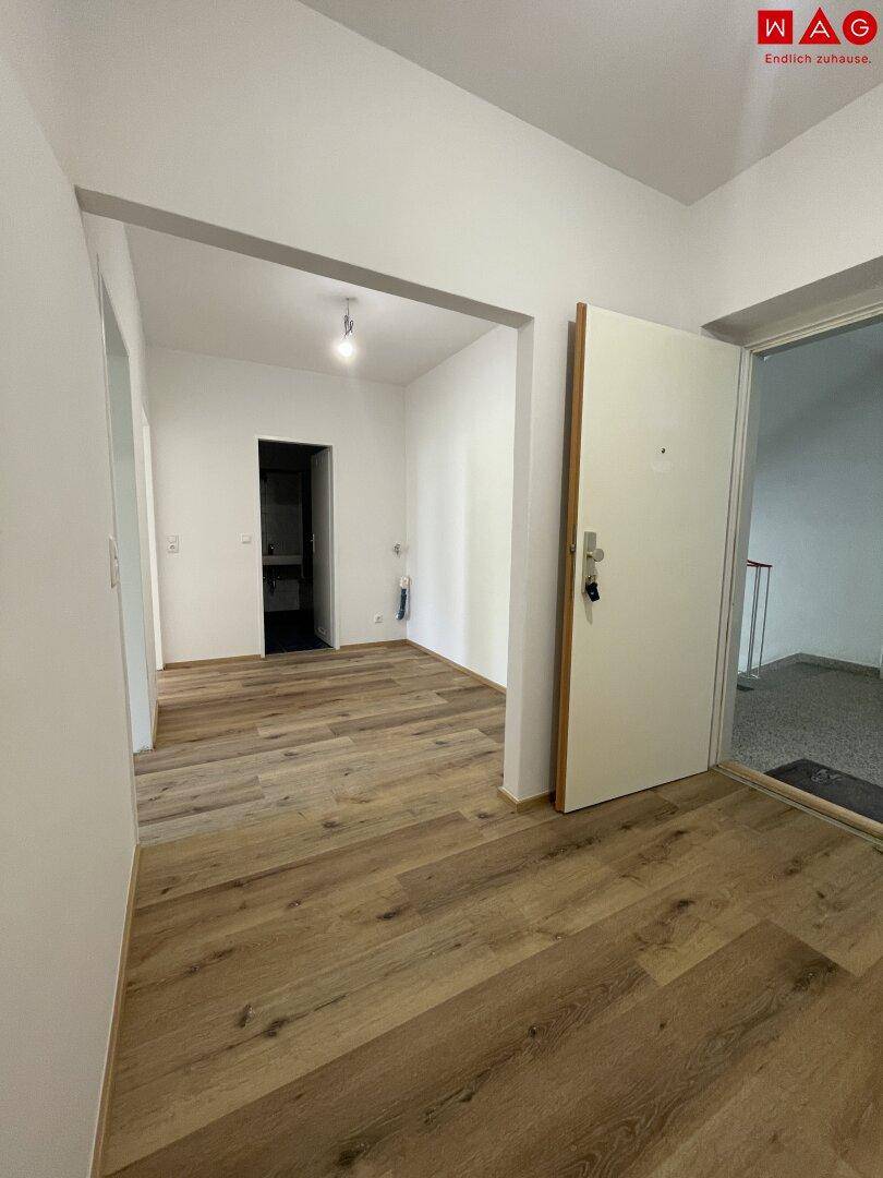 Heller Eingangsbereich mit Laminatboden und Zugang zu verschiedenen Räumen.