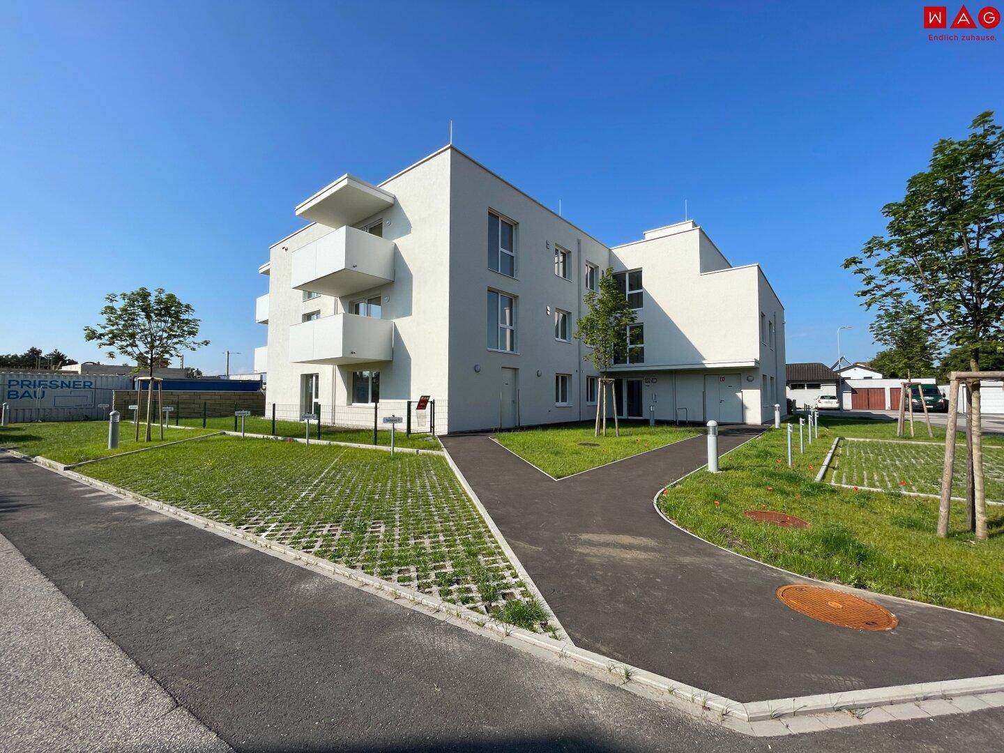 Neubau-Wohngebäude mit moderner Architektur, Balkonen und angelegten Grünflächen im Außenbereich.