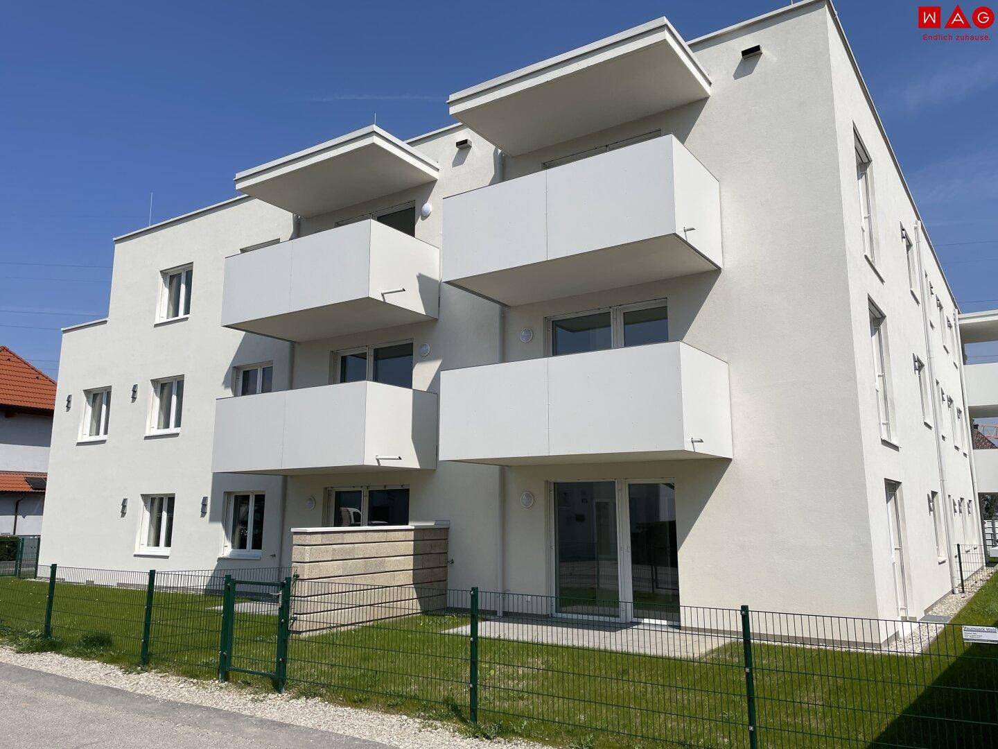 Ansicht des modernen Mehrfamilienhauses mit mehreren Balkonen und sauberer Fassade.