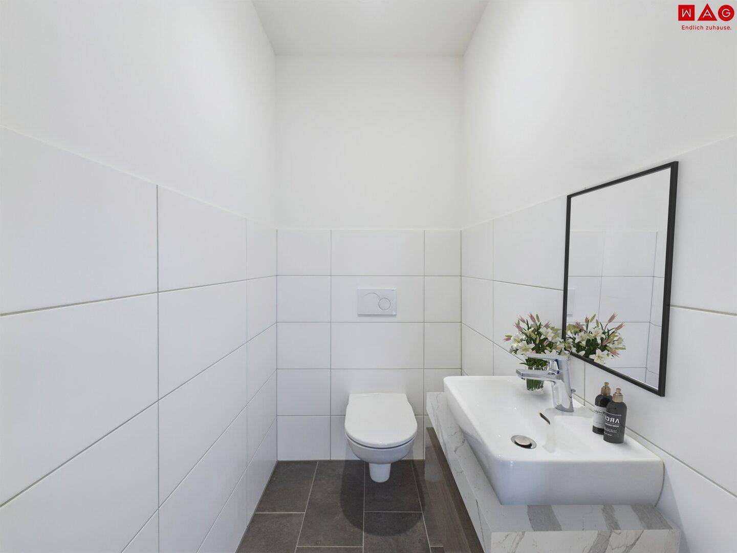 Gäste-WC mit modernem Waschbecken, wandhängender Toilette und Spiegel.