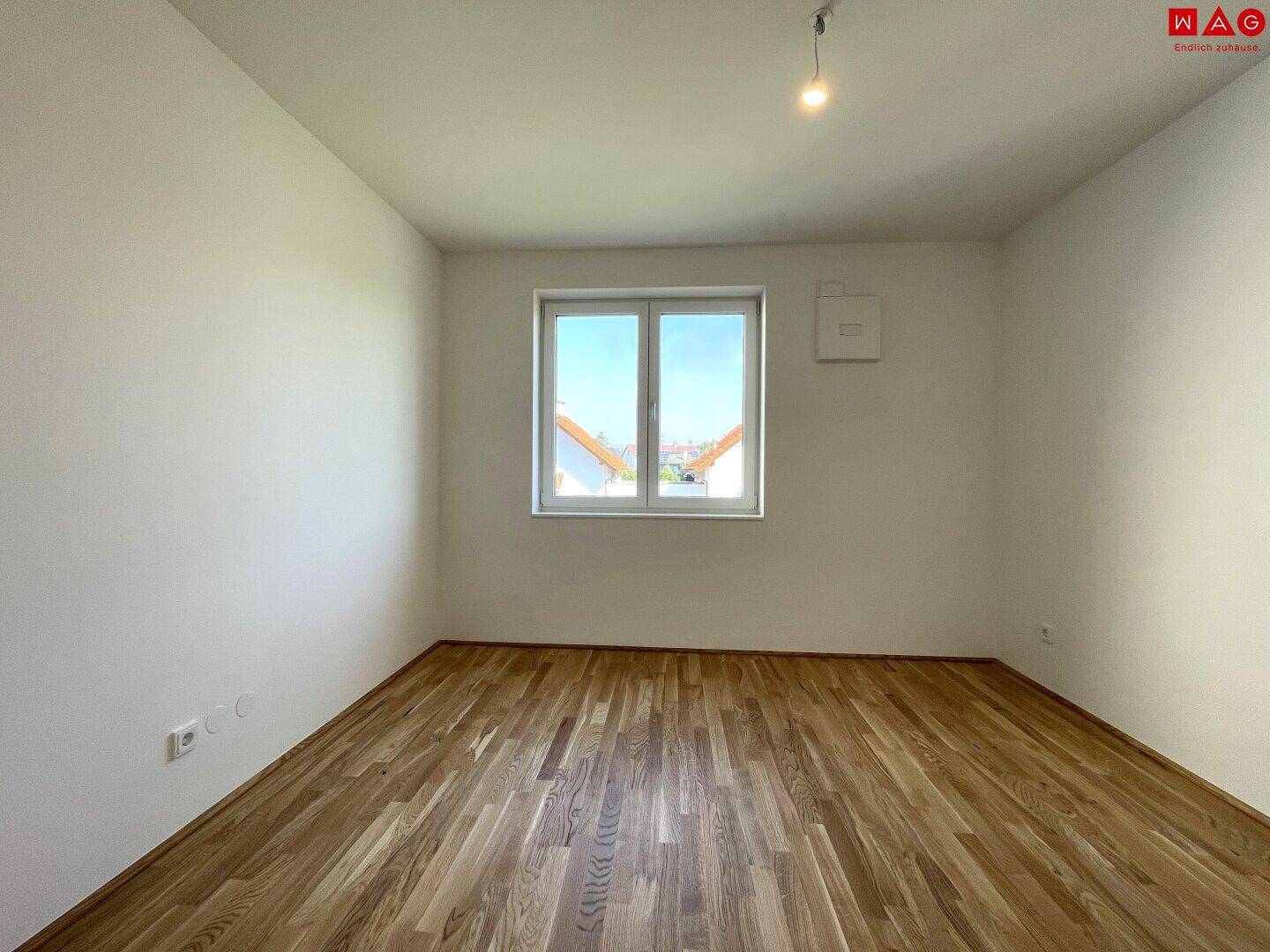 Geräumiges Schlafzimmer mit Holzboden und Fenster, bietet viel Platz für persönliche Gestaltung.