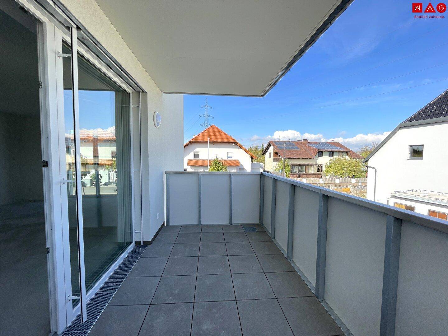 Geräumiger Balkon mit Fliesenboden und moderner Brüstung, bietet Platz für individuelle Gestaltung.