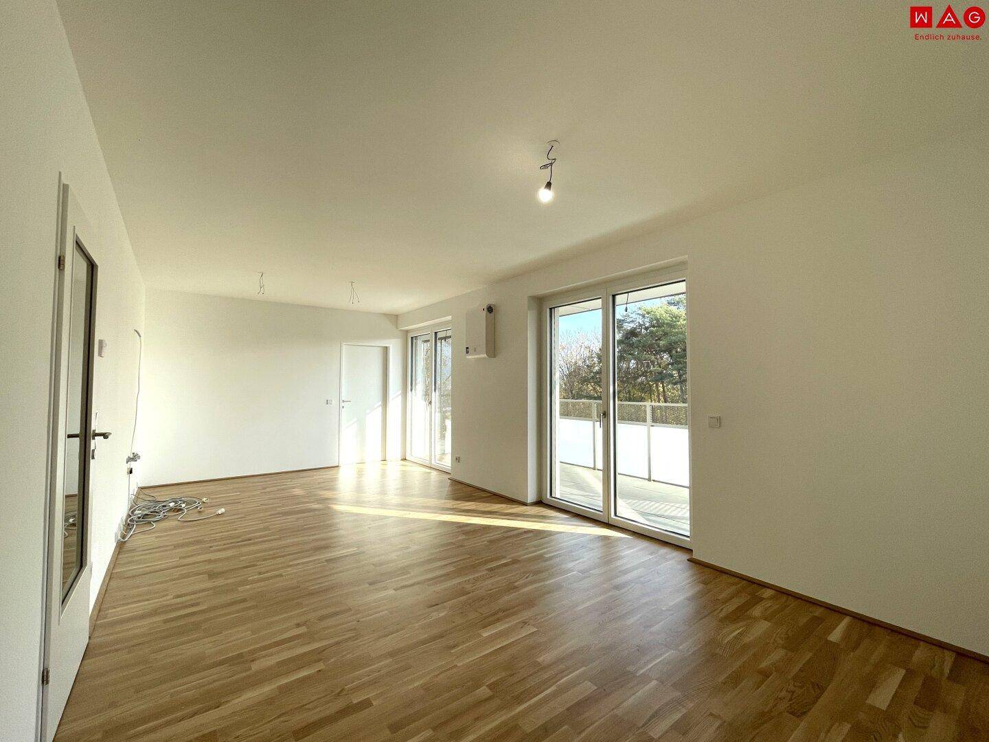 Helles, geräumiges Zimmer mit Parkettboden und Zugang zu einem sonnigen Balkon.