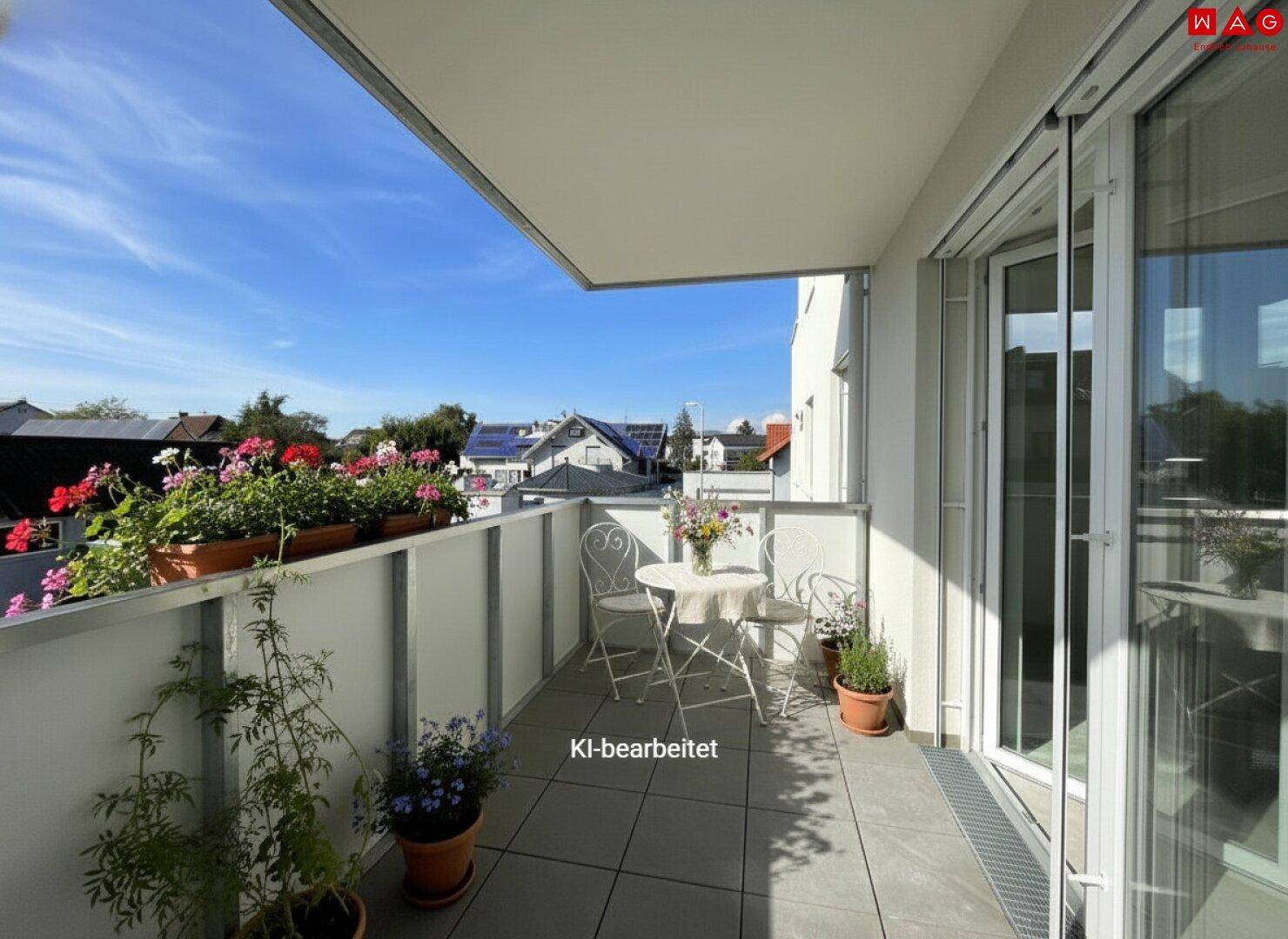 Möblierter Balkon mit Pflanzen und Blick auf die umliegenden Häuser und den Himmel.