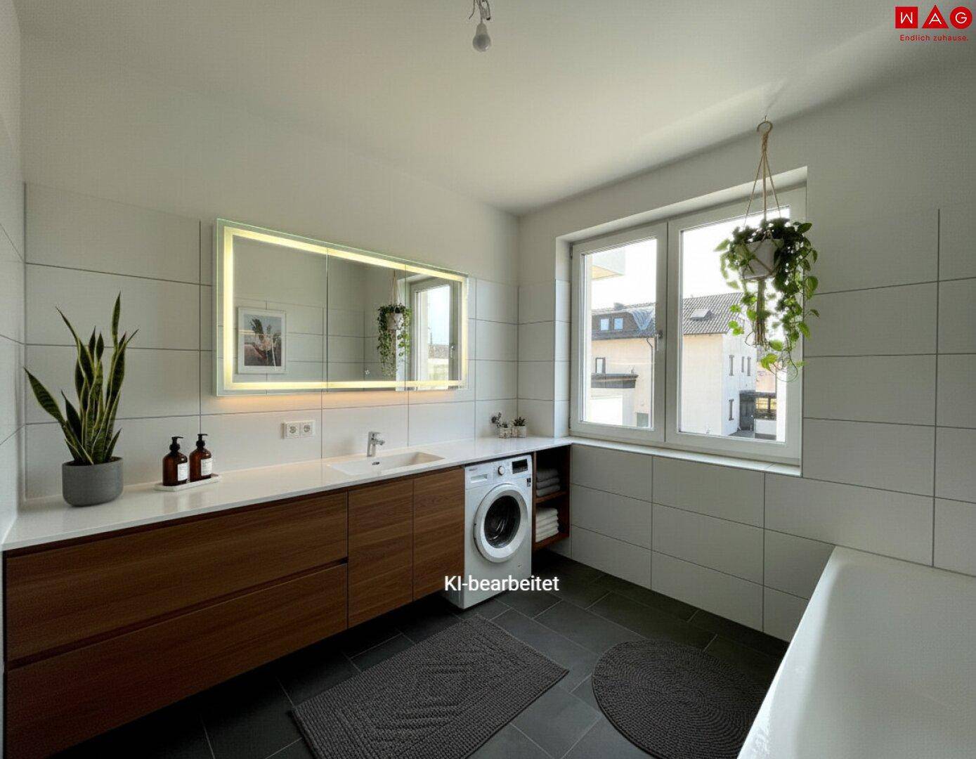 Modernes Badezimmer mit Waschmaschine, großem Waschtisch und beleuchtetem Spiegel.