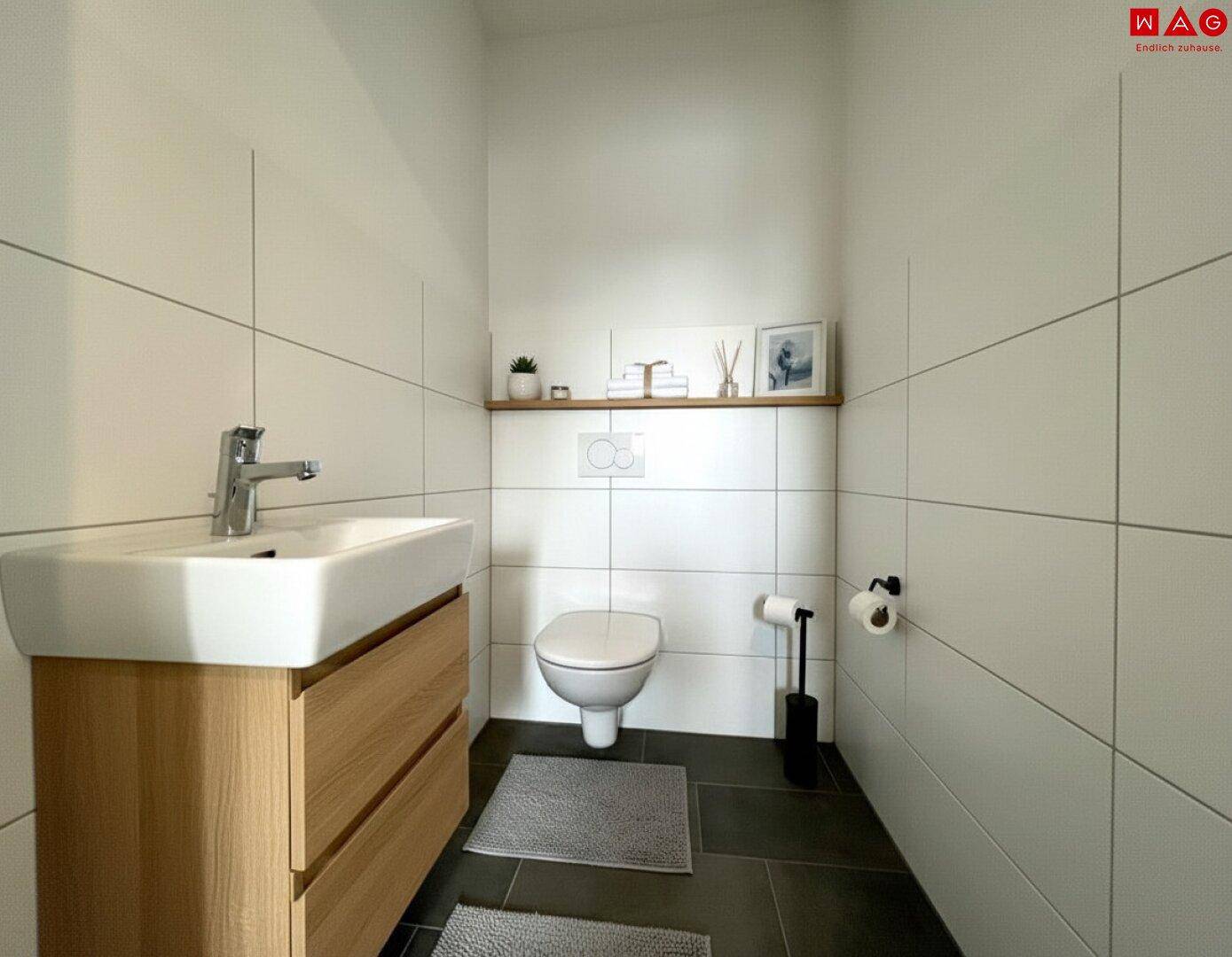 Modernes Gäste-WC mit wandhängender Toilette, Waschtisch und stilvoller Dekoration.