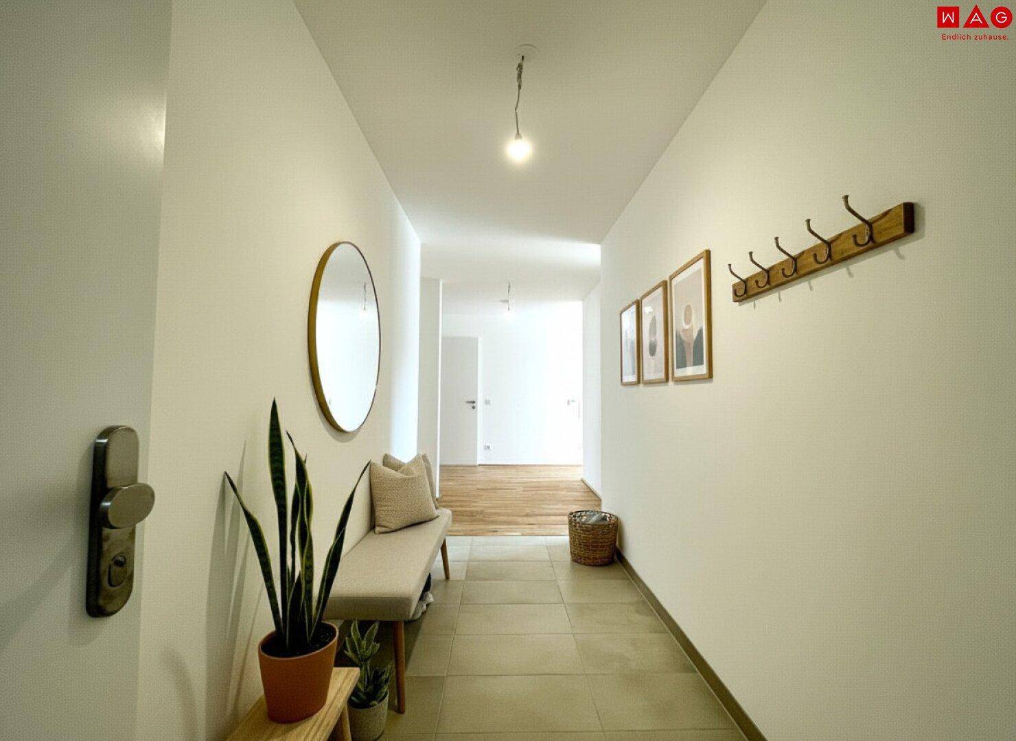 Heller Eingangsbereich mit Fliesenboden, Garderobe und modernem Spiegel.
