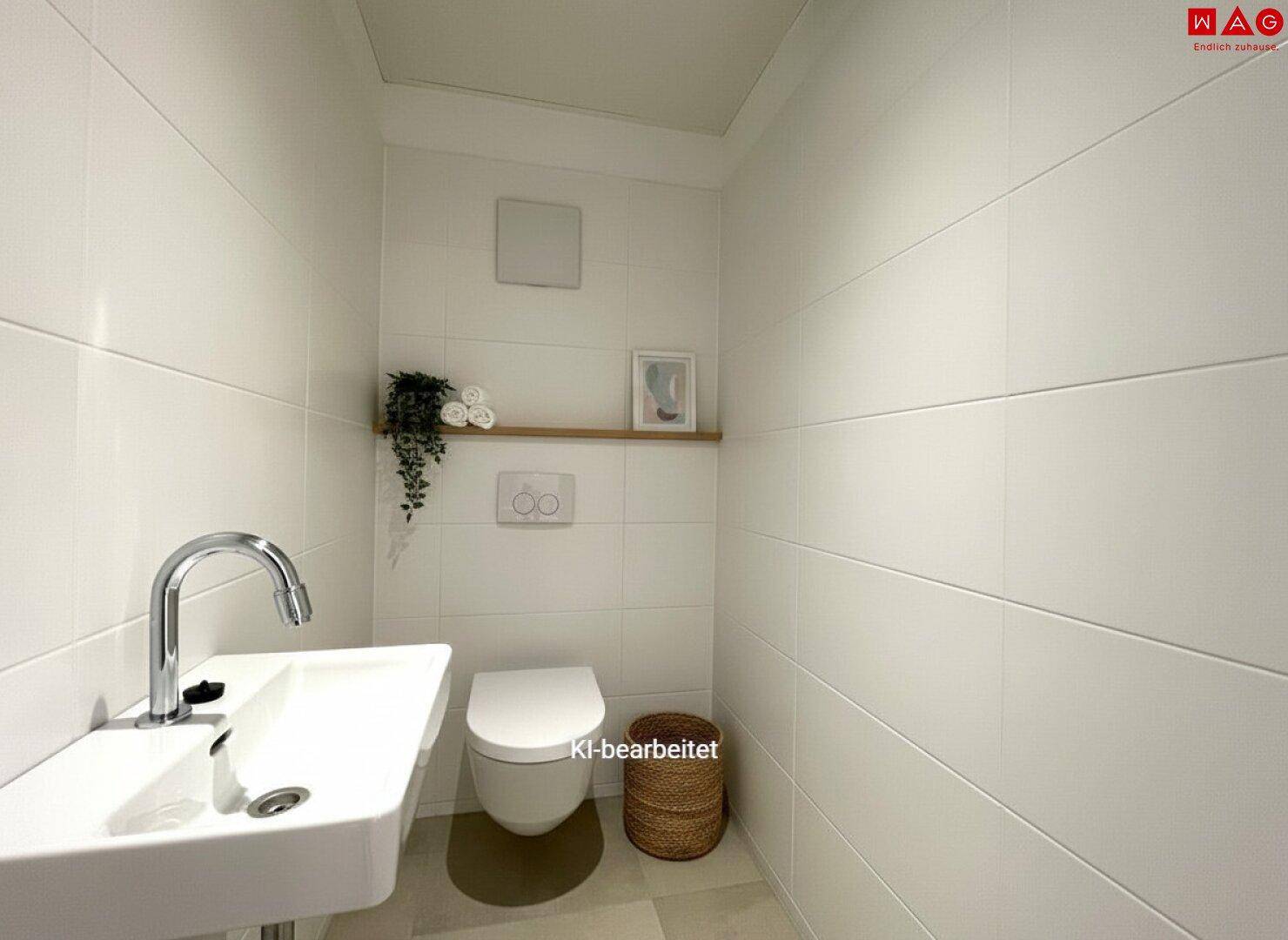 Modernes Gäste-WC mit wandhängender Toilette, kleinem Waschtisch und Fliesenboden.
