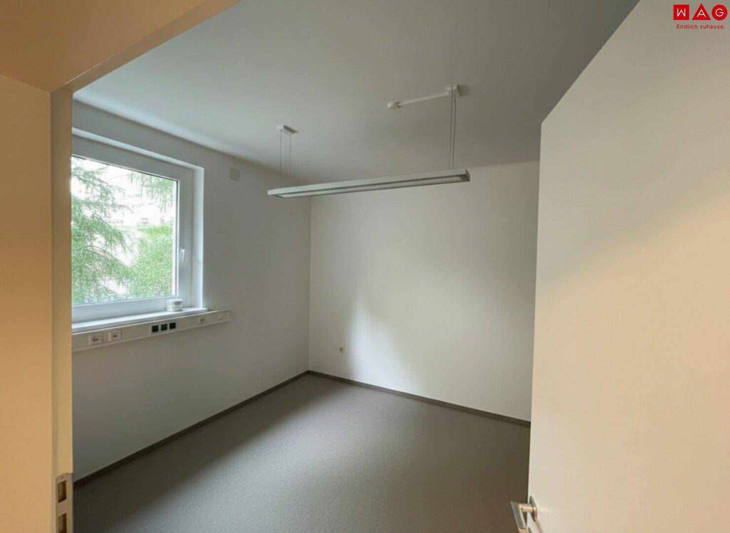 Kleineres, helles Büro mit einem Fenster und neutralem Boden, geeignet für Einzelarbeitsplätze.