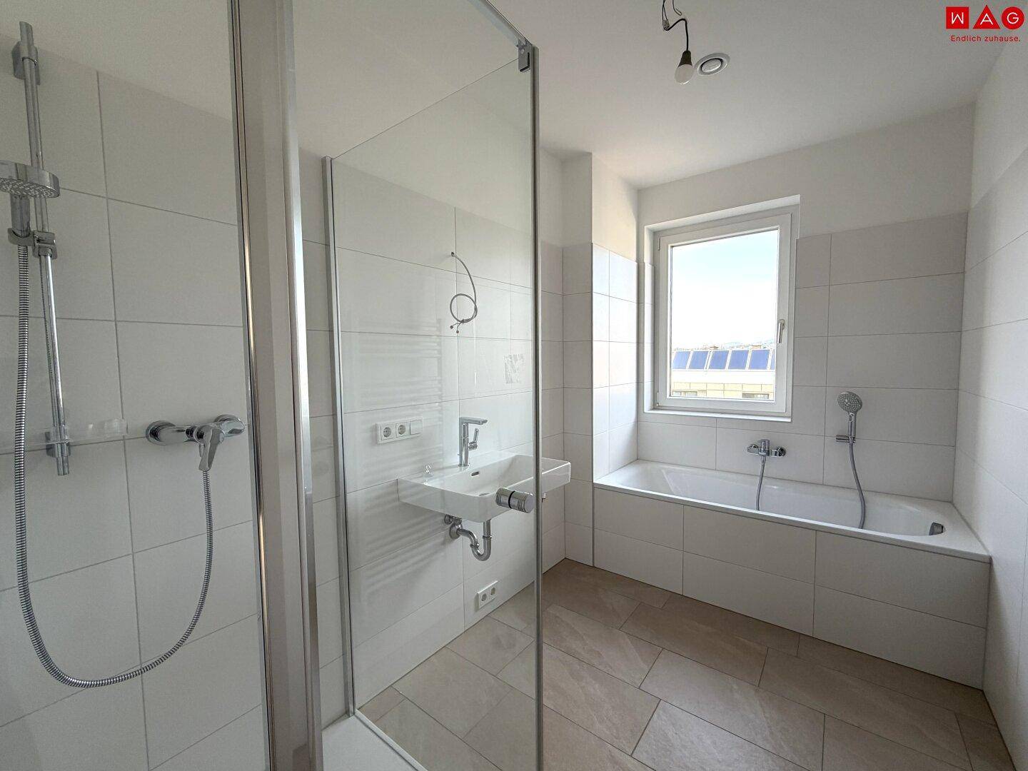 Helles Badezimmer mit Badewanne, Dusche und Fenster, bereit für individuelle Einrichtung.