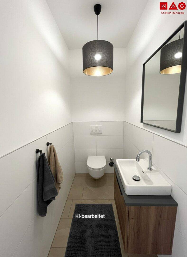 Modernes Gäste-WC mit Wand-WC und Waschbecken, hell gefliest.