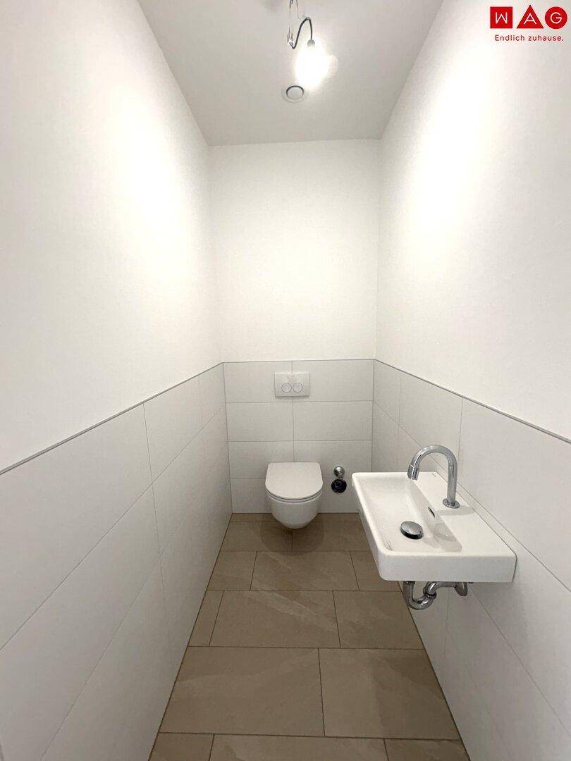 Helles Gäste-WC mit Wand-WC und Waschbecken, bereit für individuelle Gestaltung.