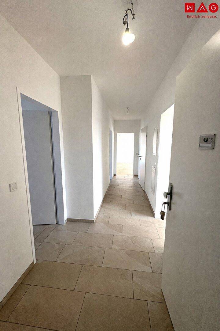 Heller Flur mit Fliesenboden, bietet Zugang zu den verschiedenen Wohnbereichen.