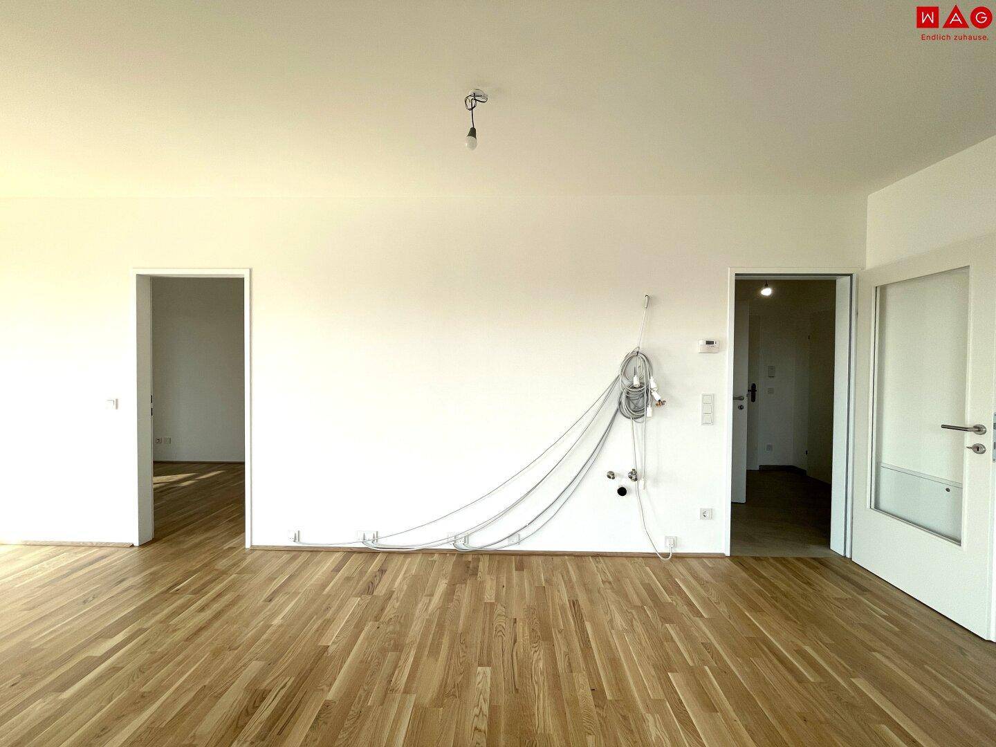 Heller, leerer Raum mit Parkettboden und weißen Wänden, bereit zur individuellen Gestaltung.