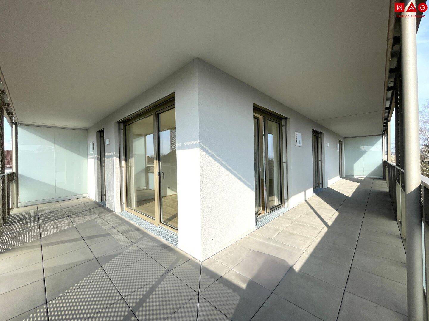 Geräumiger, sonniger Balkon mit Fliesenboden und Glasbrüstung, bereit zur Gestaltung.