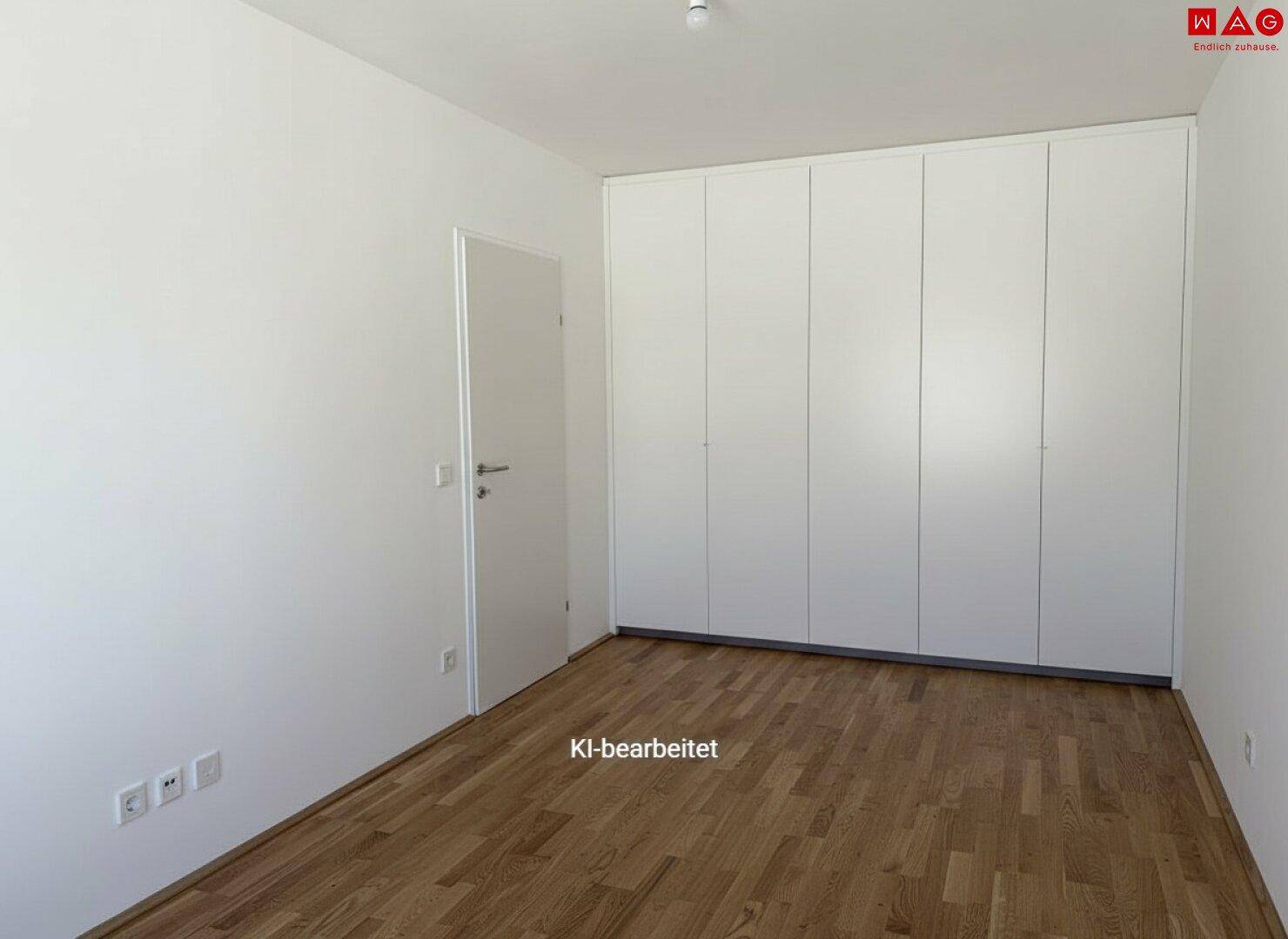 Helles Zimmer mit Holzboden und praktischen Einbauschränken entlang einer Wand.