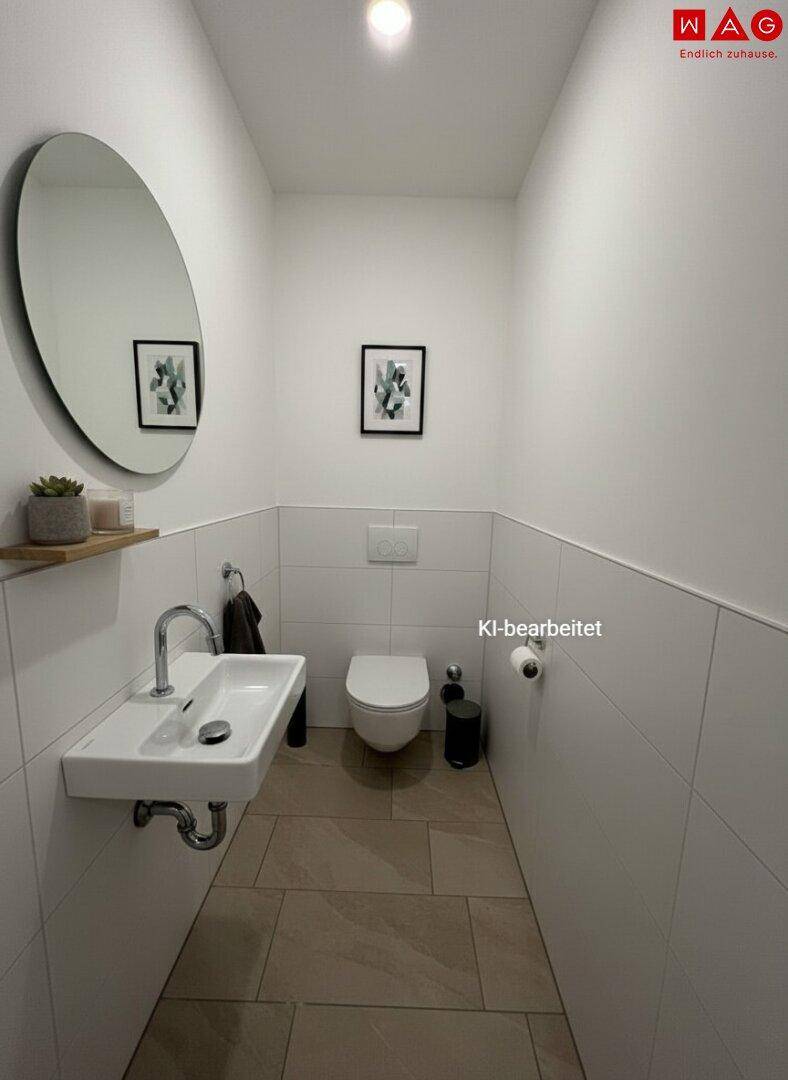 Modernes Gäste-WC mit wandhängendem WC, kleinem Waschbecken und Spiegel.