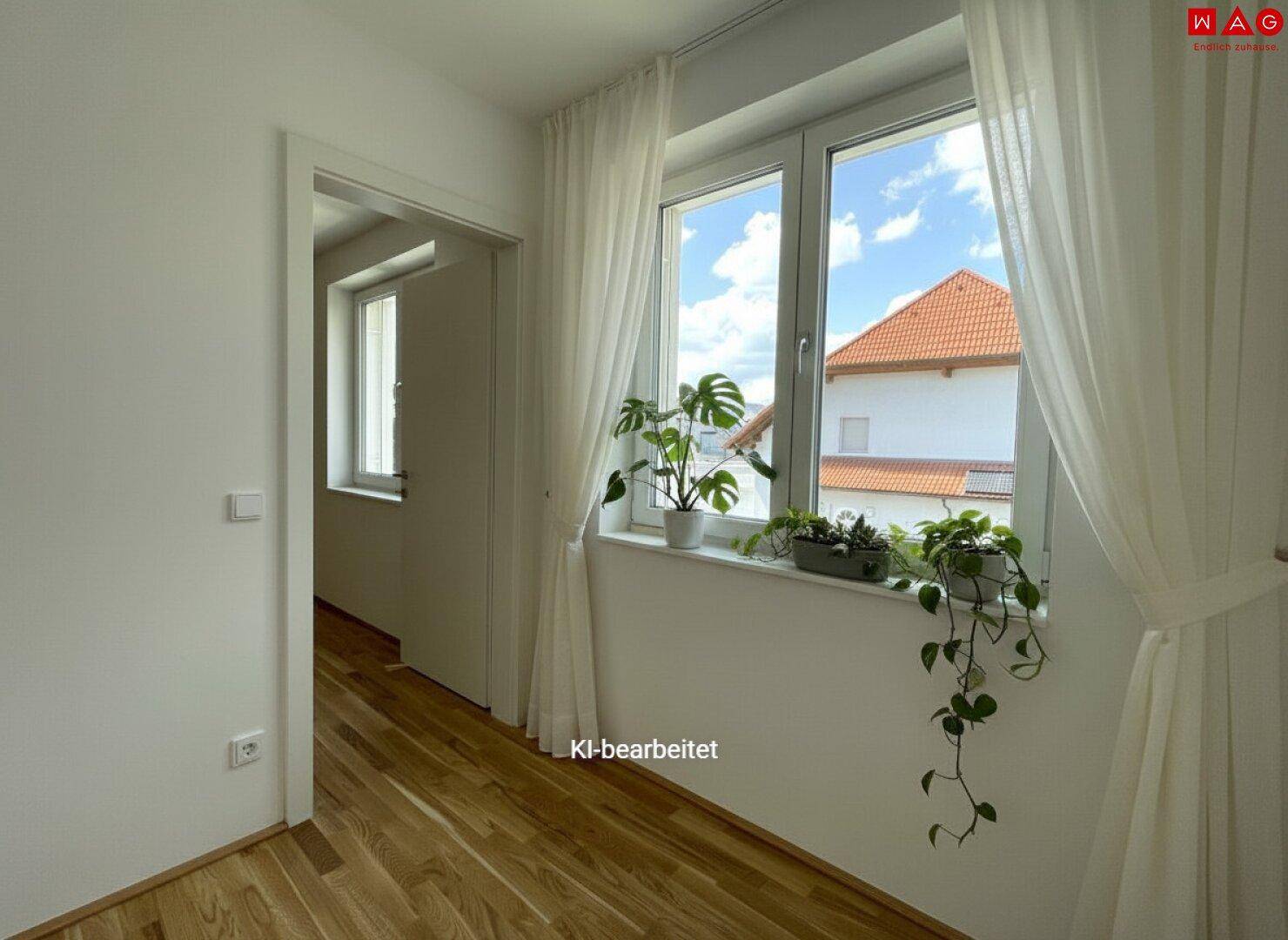 Heller Raum mit Eichenparkettboden, großen Fenstern und Pflanzen, die eine angenehme Atmosphäre schaffen.