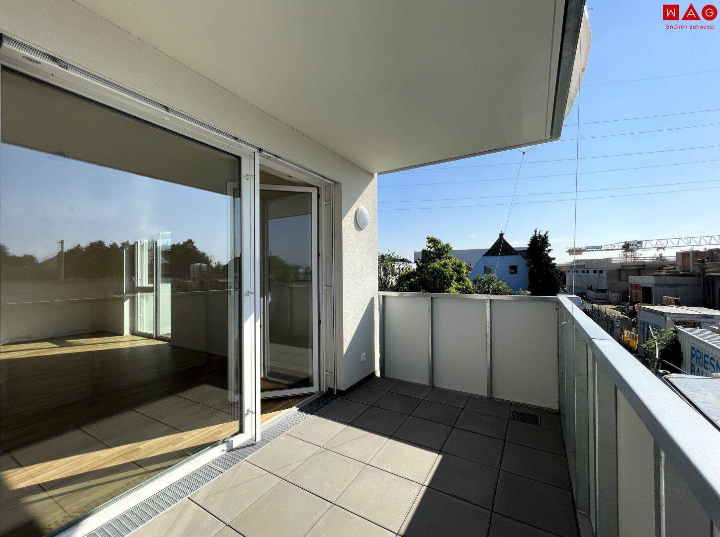 Geräumiger Balkon mit Fliesenboden und weitem Blick auf die Umgebung.